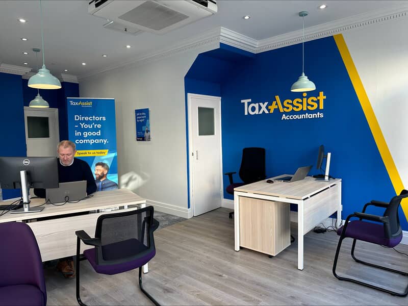 A image of the inside of a TaxAssist office showing consistent branding in the wall graphics and banners.